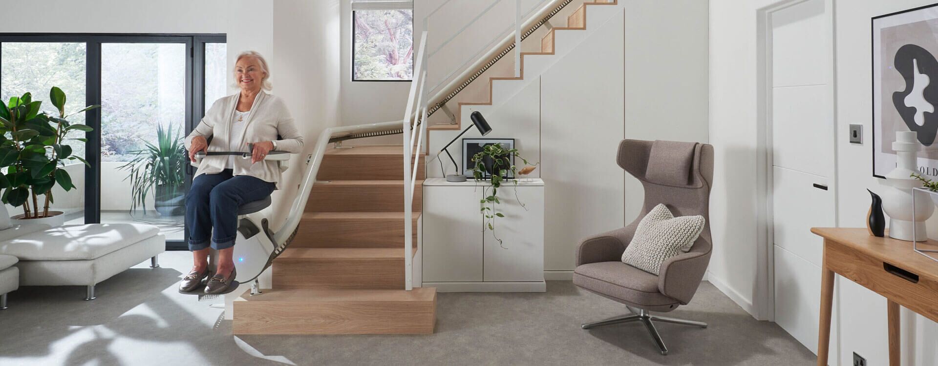 Frau auf Sitzlift Treppenlift - Modell Flow X von Access 1 Rohrsystem